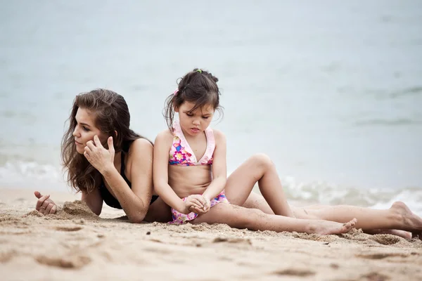 Žena a dívka relaxaci na pláži — Stock fotografie