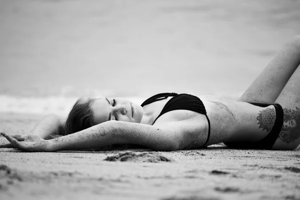 Frau liegt am Sandstrand — Stockfoto