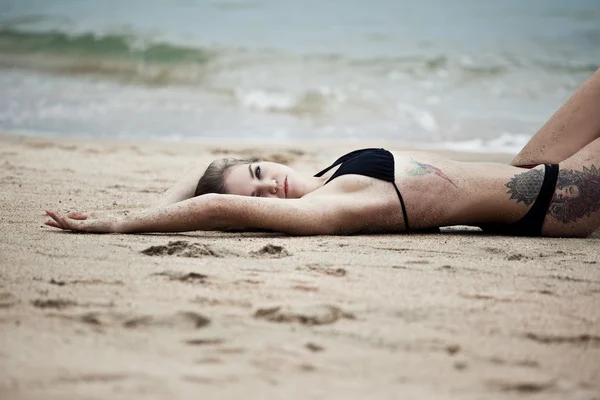 Женщина лежит на песчаном пляже — стоковое фото