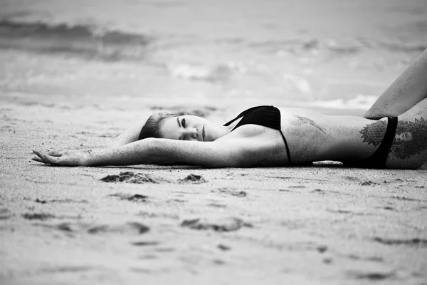 Frau liegt am Sandstrand — Stockfoto