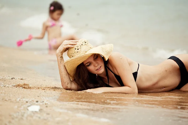Mulher deitada na praia de areia — Fotografia de Stock