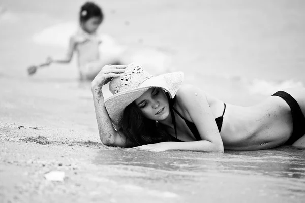 Жінка і маленька дівчинка розслабляється на пляжі — стокове фото