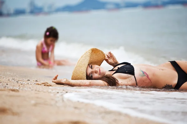 Mujer y niña relajándose en la playa — Foto de Stock