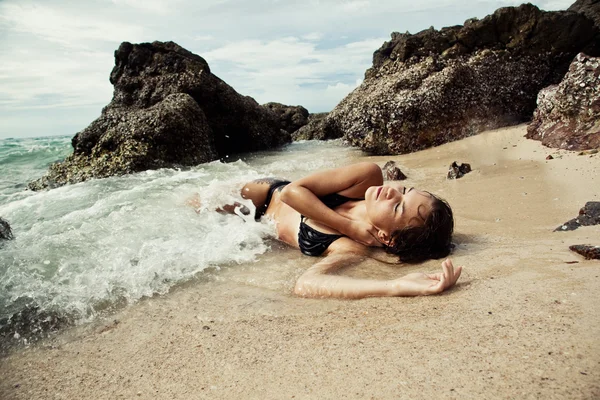 Жінка лежить на піщаному пляжі — стокове фото