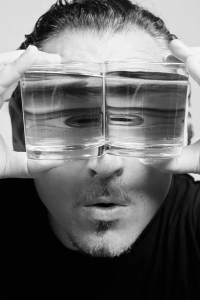 Reflection of a male face in glasses with liquid — Stock Photo, Image