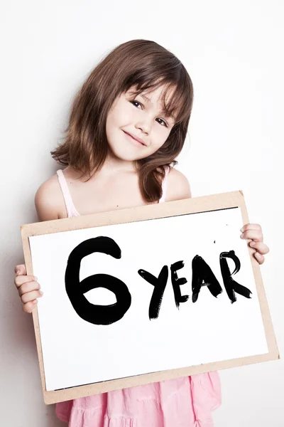 Girl holding banner with text "6 year" — Stock Photo, Image