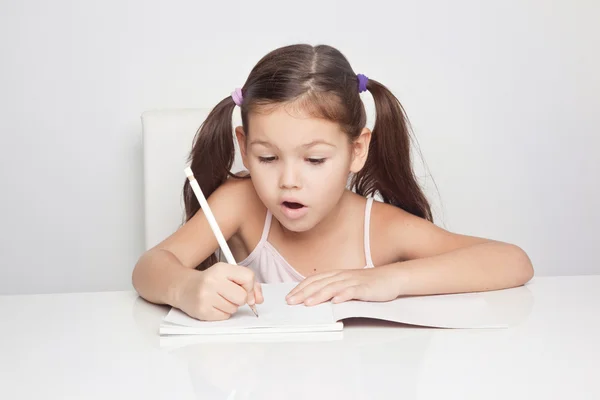 Menina escrevendo em um caderno — Fotografia de Stock