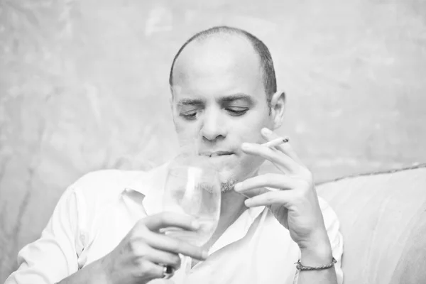 Man drinking wine and smoking