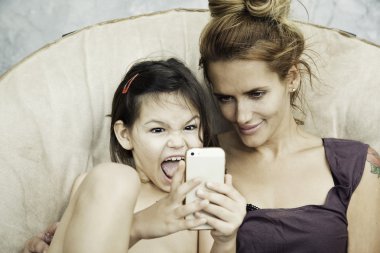 Anne ve kızı telefon oyun oynuyor  