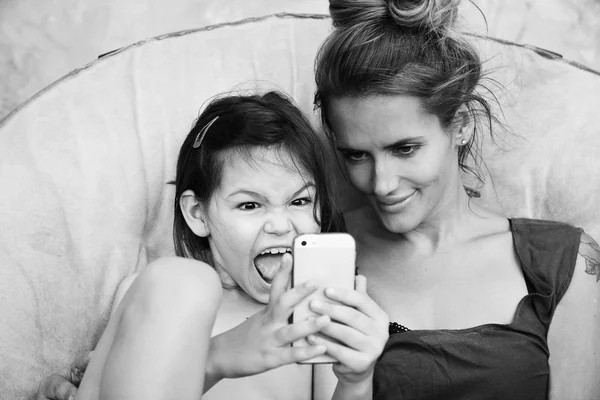 母と娘の携帯電話のゲームをプレイ — ストック写真