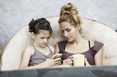 Anne ve kızı telefon oyun oynuyor  