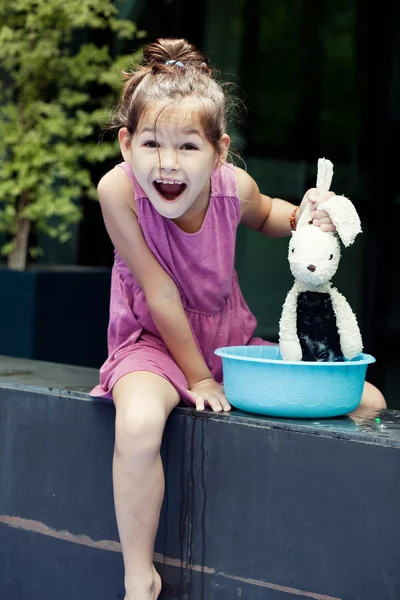 Malá holčička omývá její hračka — Stock fotografie