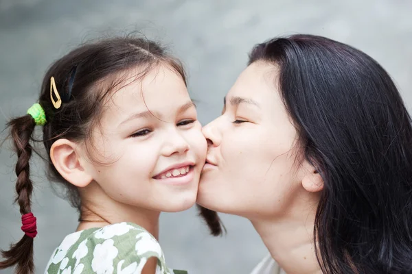 Mother kissing daughter — Stock Photo, Image