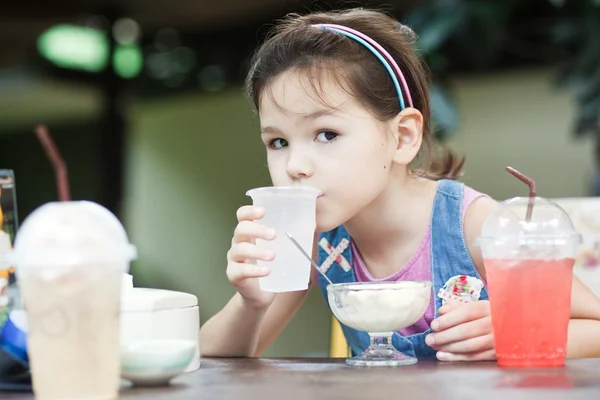 Девушка ест мороженое в кафе — стоковое фото