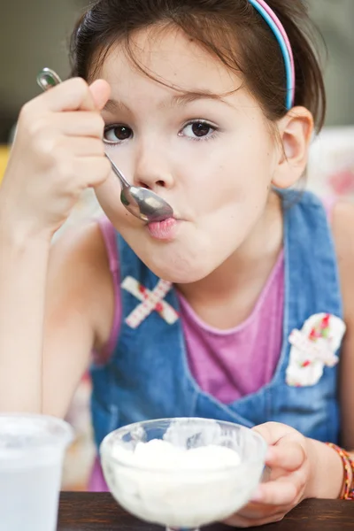 Девушка ест мороженое в кафе — стоковое фото