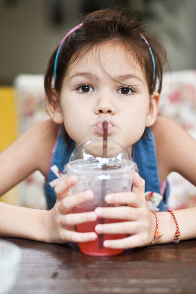 Девушка пьет сок в кафе
 