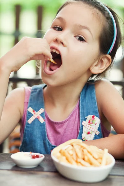 Niña comiendo papas fritas — Foto de Stock