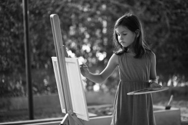 küçük kız bir resim çizer.