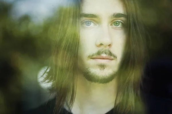 guy with long hair  outside the window