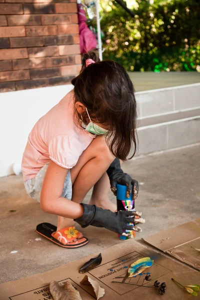 Chica pinta hojas con pintura en aerosol — Foto de Stock