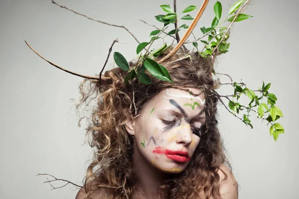 Frau mit einem Kranz aus Blättern und Zweigen — Stockfoto