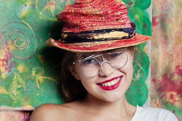 Женщина в очках в креативной красной шляпе — стоковое фото