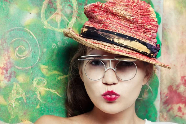 Женщина в очках в креативной красной шляпе — стоковое фото