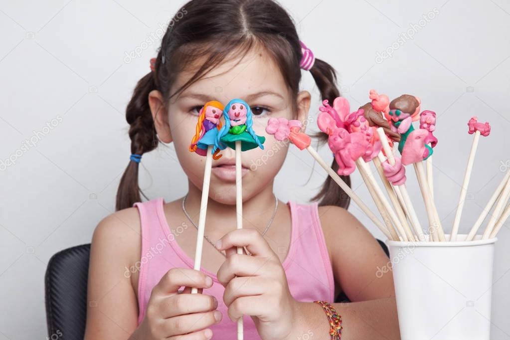 Girl playing puppet theater from clay