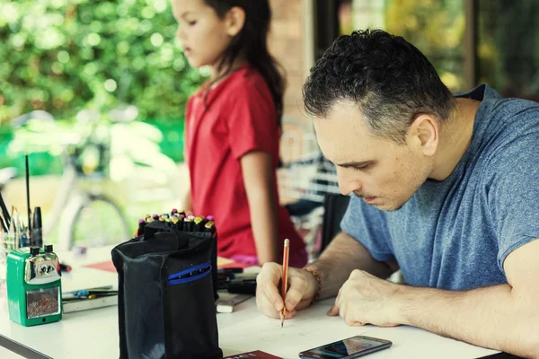 Dad and daughter drawing together