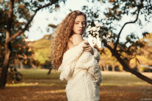 A mulher com cabelo encaracolado andando no parque de outono — Fotografia de Stock