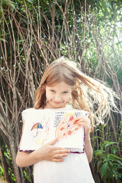 Retrato Sorrir Menina Mostrando Desenhos Perto Árvores Jardim — Fotografia de Stock