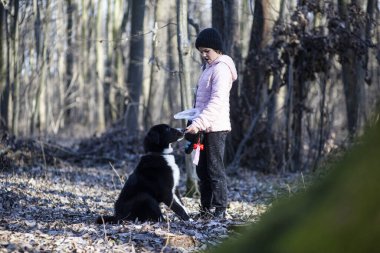 Ormanda köpek gezdiren bir kız.