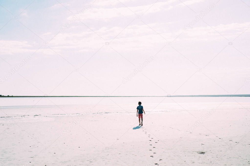  boy walking along beach 