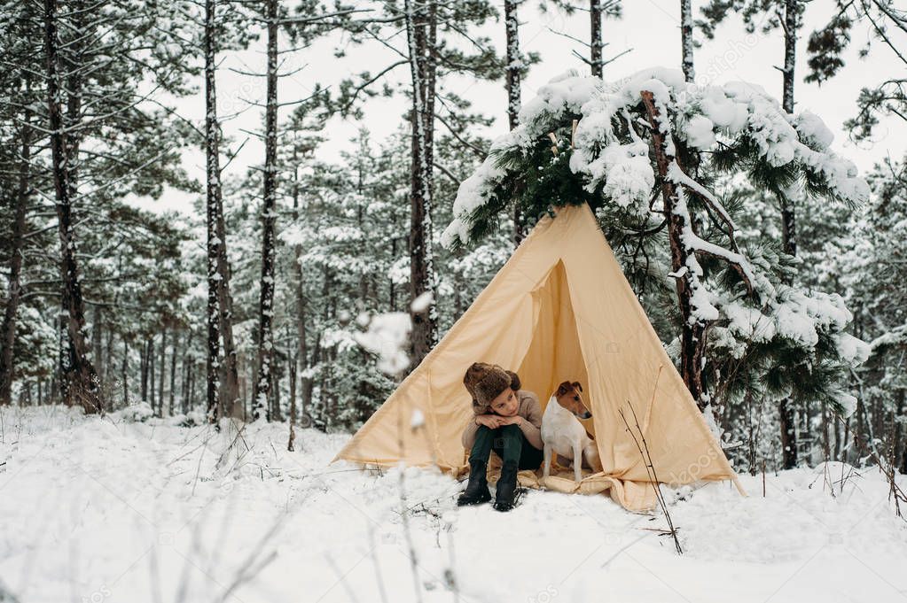  boy sitting in tent with dog