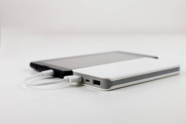 Tablet bilgisayar üzerinden harici pil, turuncu bir arka plan üzerinde kullanılıyorsa.