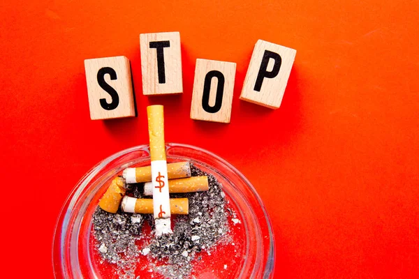 Pare de fumar - bloquear letras de madeira com cinzeiro no fundo vermelho — Fotografia de Stock