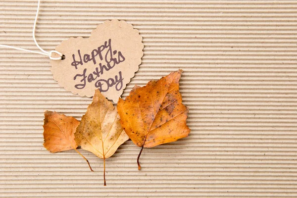 Szczęśliwy dzień ojca - serce kształt znacznika na tekturowe kartonowe tło z jesiennych liści — Zdjęcie stockowe
