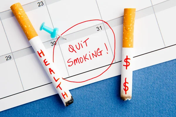 Parar de fumar - Calendário - Saúde e dinheiro - com cigarros no fundo azul — Fotografia de Stock