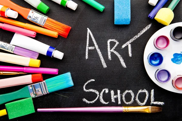 Art School - handwritten on chalkboard surrounded by art equipment — Stock Photo, Image