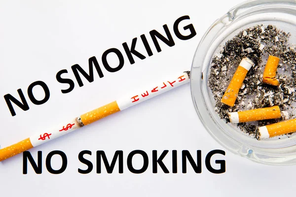 Proibido fumar - com cigarros e cinzeiro com palavras impressas sobre fundo azul e branco — Fotografia de Stock