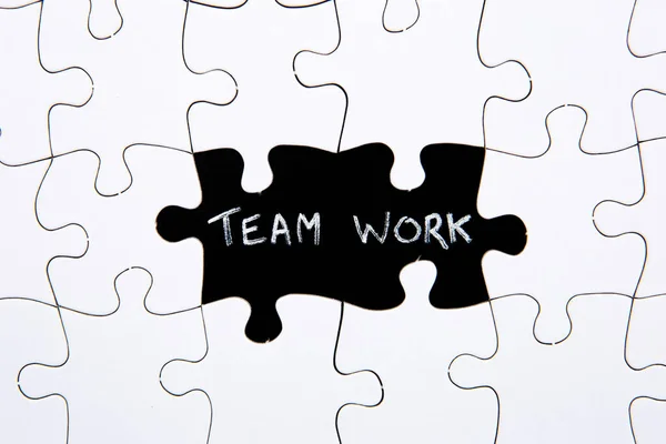 Puzzle Pieces - with word Team Work in black chalkboard space