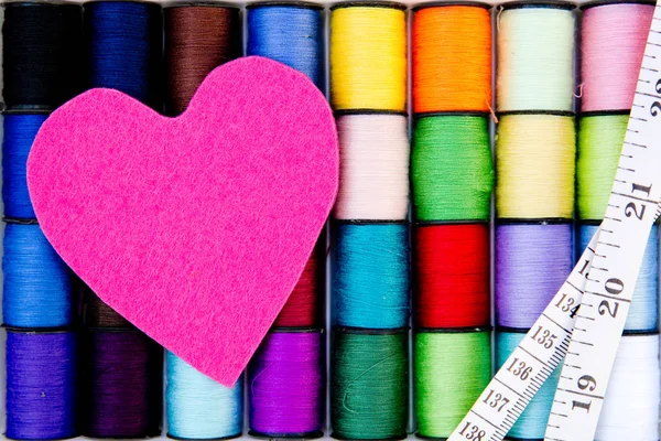 Sewing - Thread - Cotton Reels with pink felt heart and tape measure — Stock Photo, Image