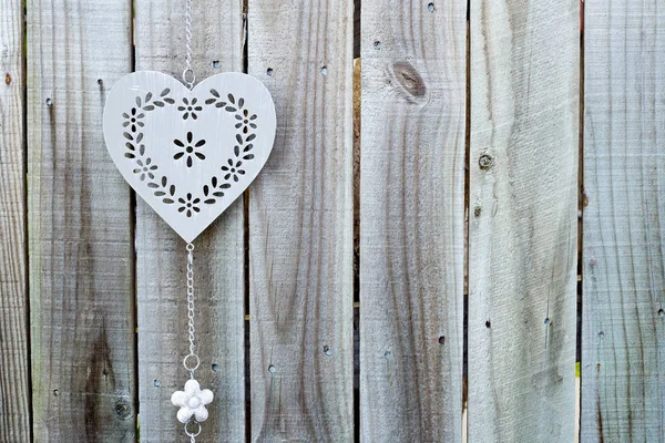 Achtergrond - decoratieve zilveren metalen hart opknoping op grijs houten hek — Stockfoto