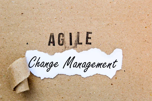 Agile Change Management - printed text underneath torn brown paper with Agile printed in ink