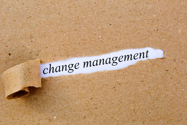 Change Management - printed text underneath torn brown paper