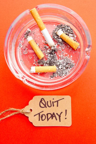 Pare de fumar - Sair hoje - com cigarros, cinzeiro e etiqueta no fundo vermelho — Fotografia de Stock
