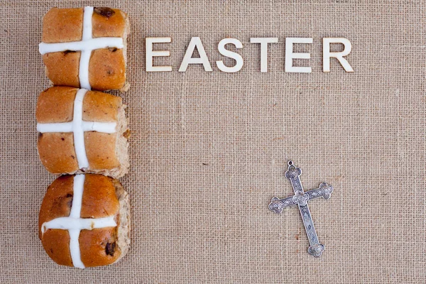 Easter - Hot cross buns with Easter in wooden letters on burlap background