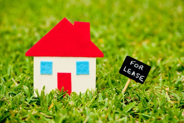 Casa - Casa - Para arrendar pizarra sobre el fondo de hierba —  Fotos de Stock