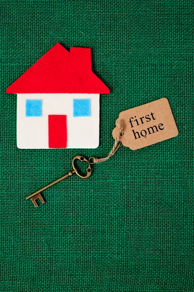 House with First Home key on green background