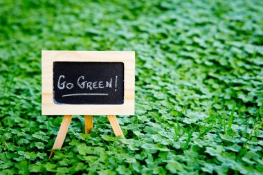 Go Green - Yeşil yonca tahta üzerinde el yazısı